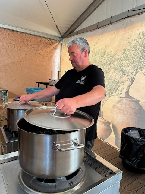 Fabien aan het werk bij de kookpotten op locatie